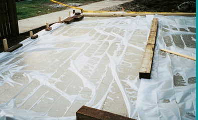 Curing of concrete by covering its surface with a sheet layer 